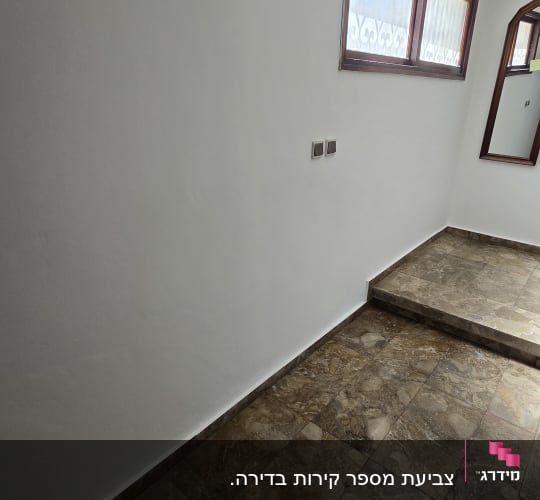 קיר צבוע ולרצפה מרוצפת באבן חומה